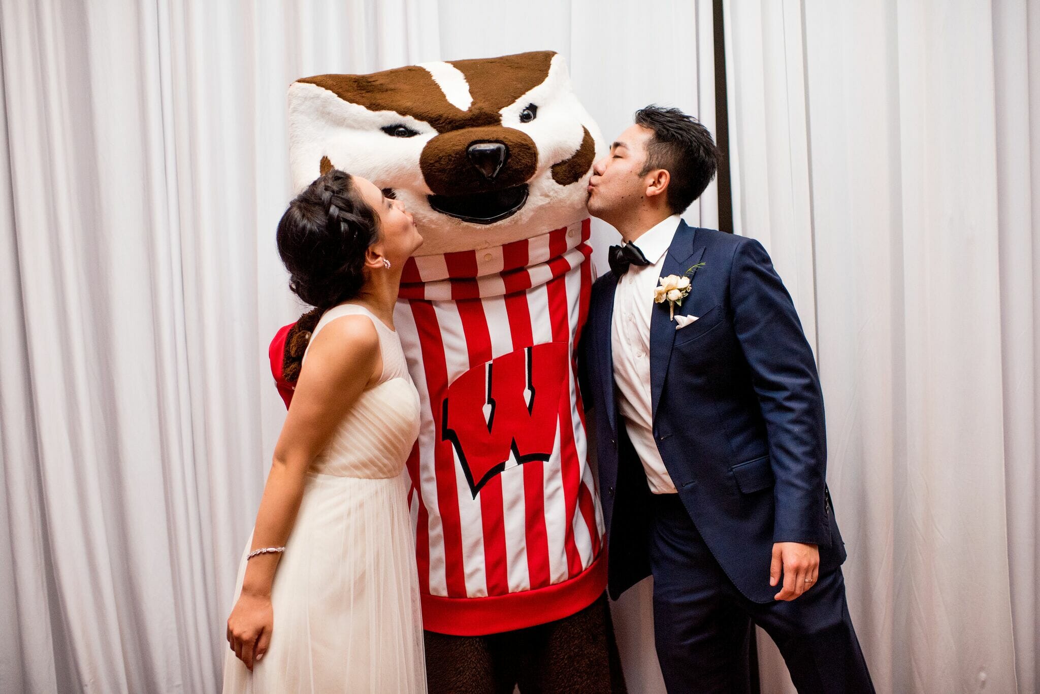 Bride and Groom Kissing Bucky Badger on Cheek